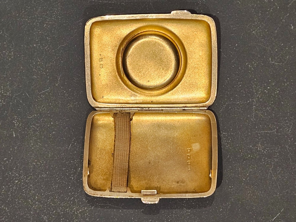 A rectangular engraved sterling silver cheroot case featuring floral motifs and an integrated circular hinged compact lid. View V
