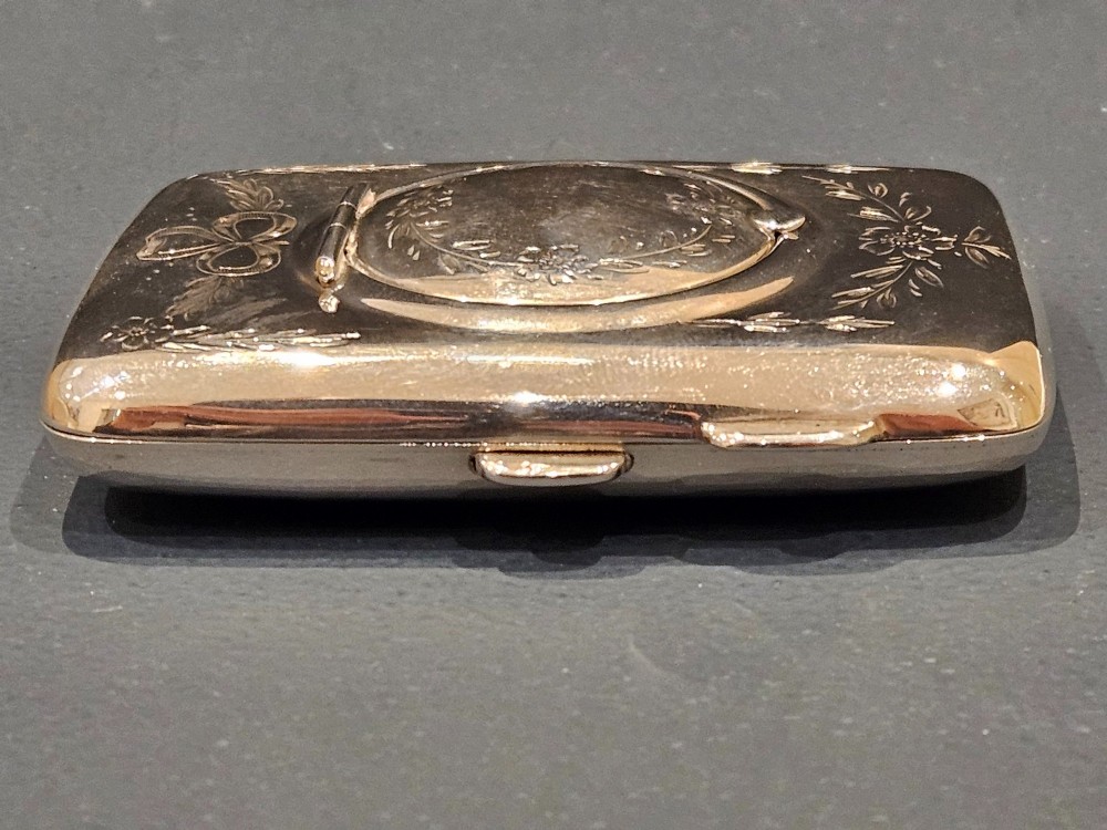 A rectangular engraved sterling silver cheroot case featuring floral motifs and an integrated circular hinged compact lid. View VI