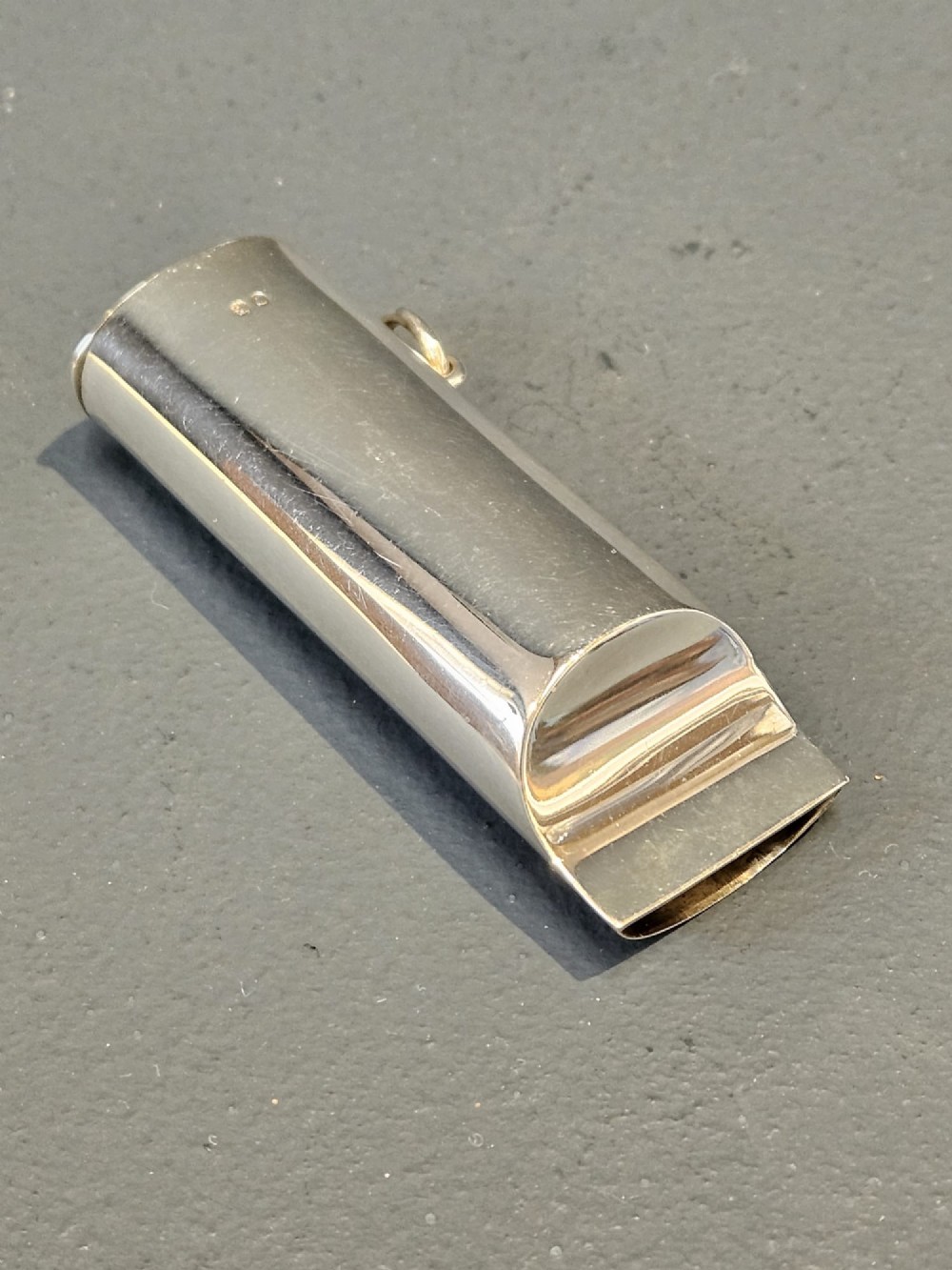 A polished Victorian sterling silver combined vesta case and whistle standing upright with a small suspension ring attached at the base. View III