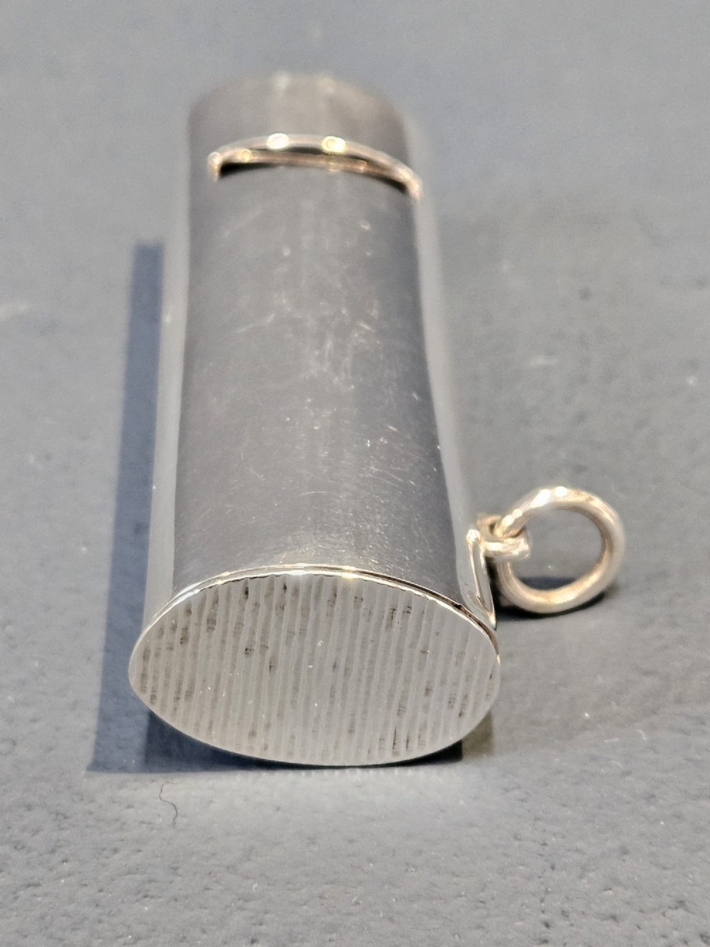 A polished Victorian sterling silver combined vesta case and whistle standing upright with a small suspension ring attached at the base. View IV