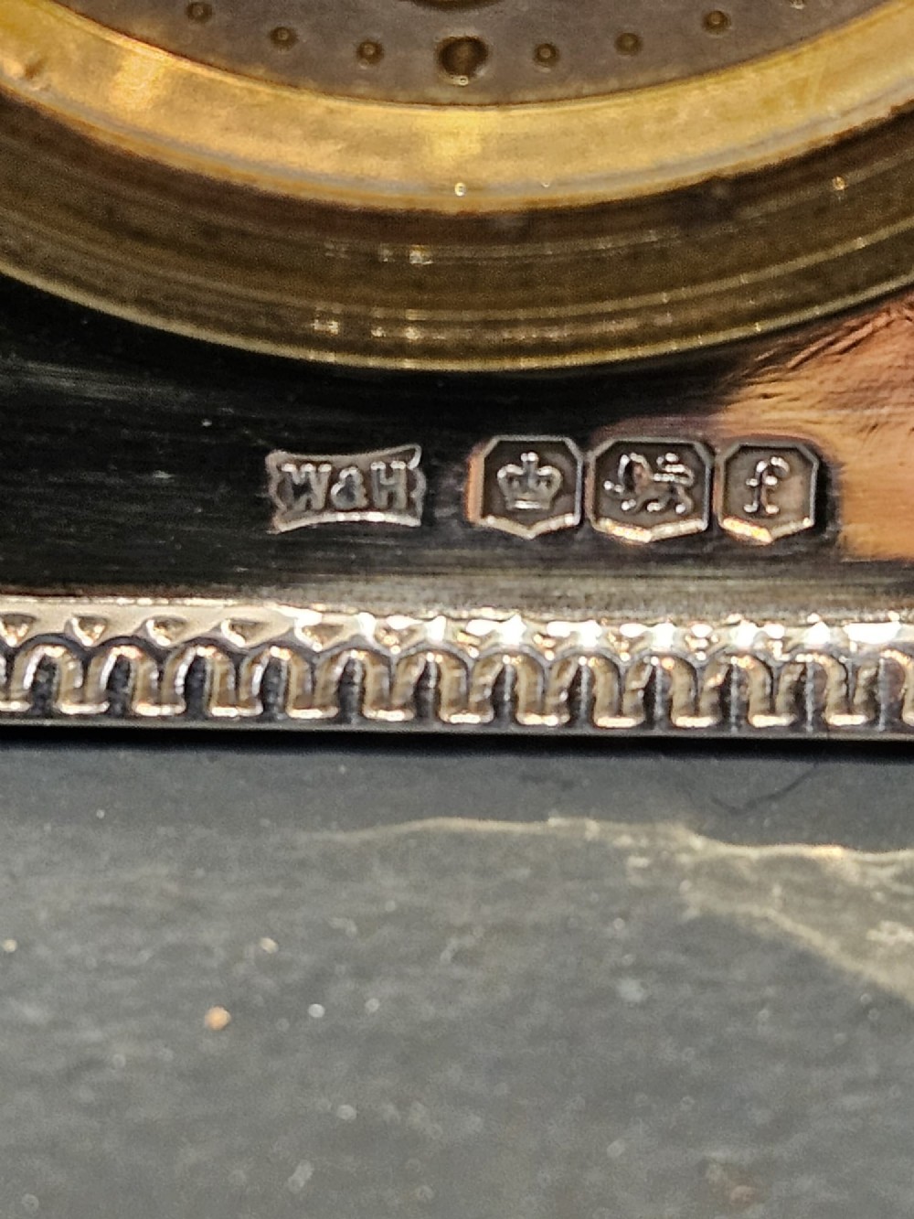 A square hallmarked sterling silver desk clock featuring a beaded outer frame, a brass inner bezel, and Arabic numerals on a metallic dial. View IV