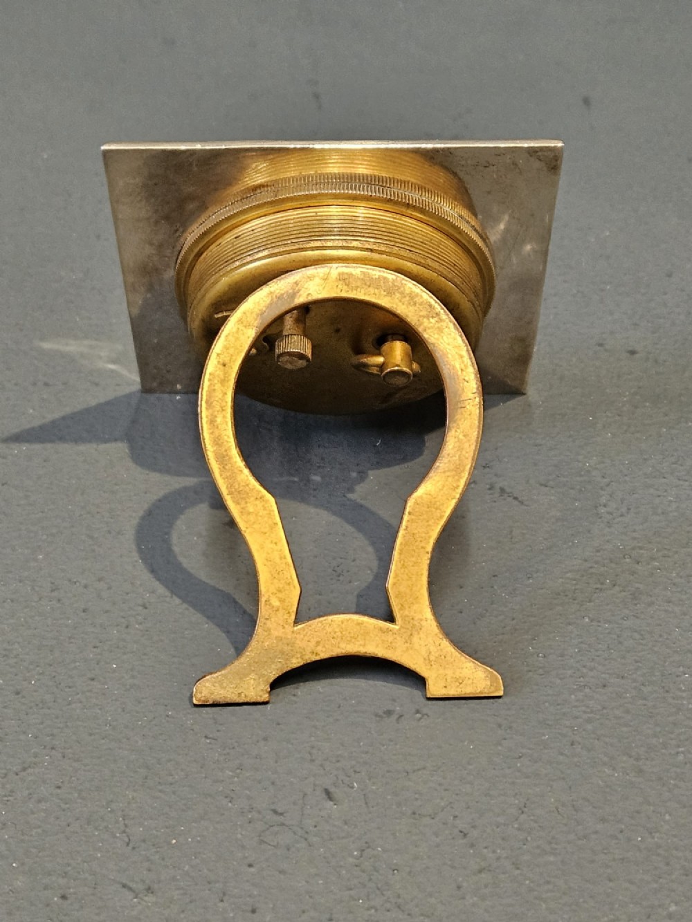 A square hallmarked sterling silver desk clock featuring a beaded outer frame, a brass inner bezel, and Arabic numerals on a metallic dial. View V
