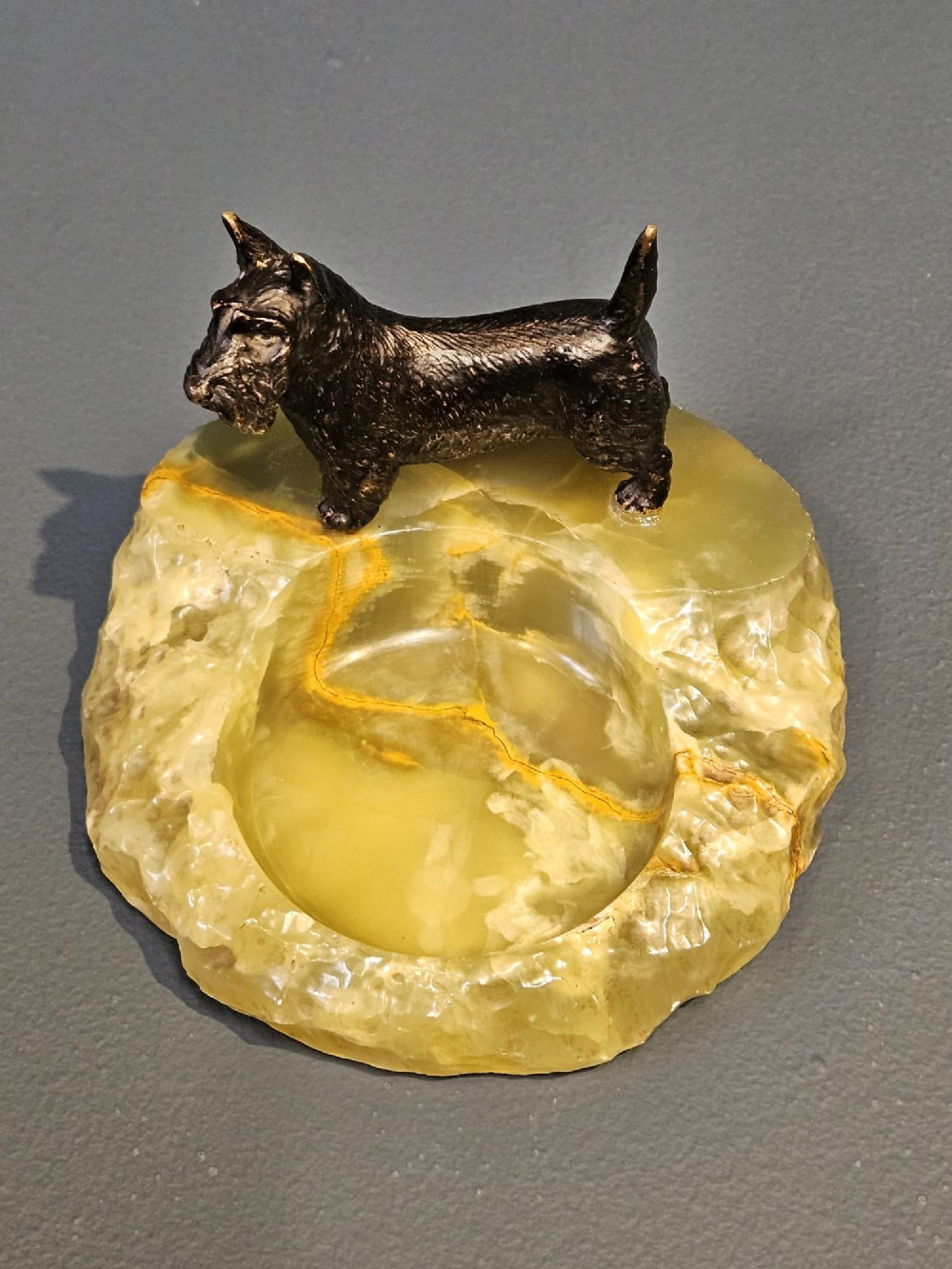A cold painted bronze Scottish Terrier figure standing on a carved pale green onyx dish with natural veining. View III