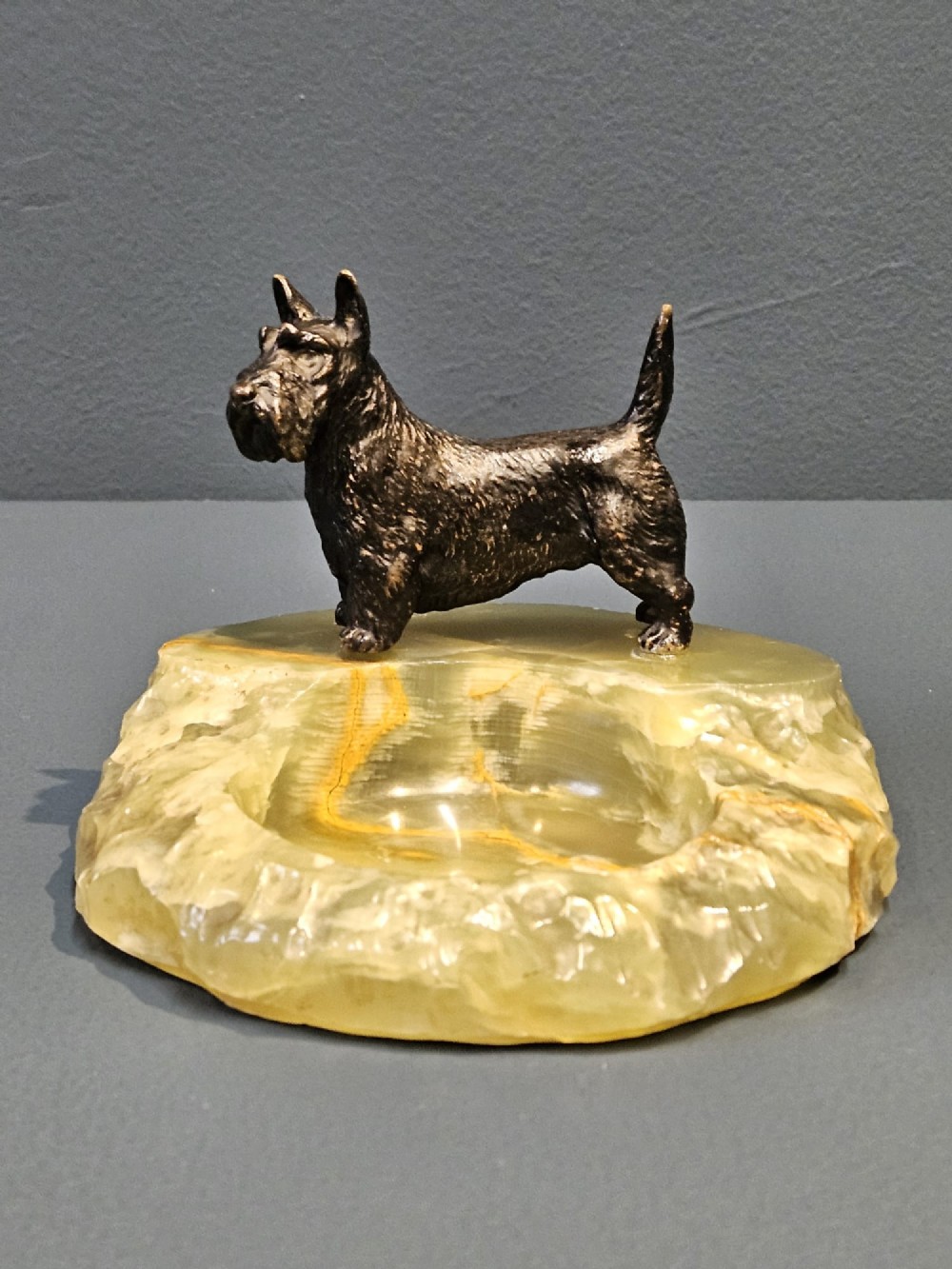 A cold painted bronze Scottish Terrier figure standing on a carved pale green onyx dish with natural veining. View IV