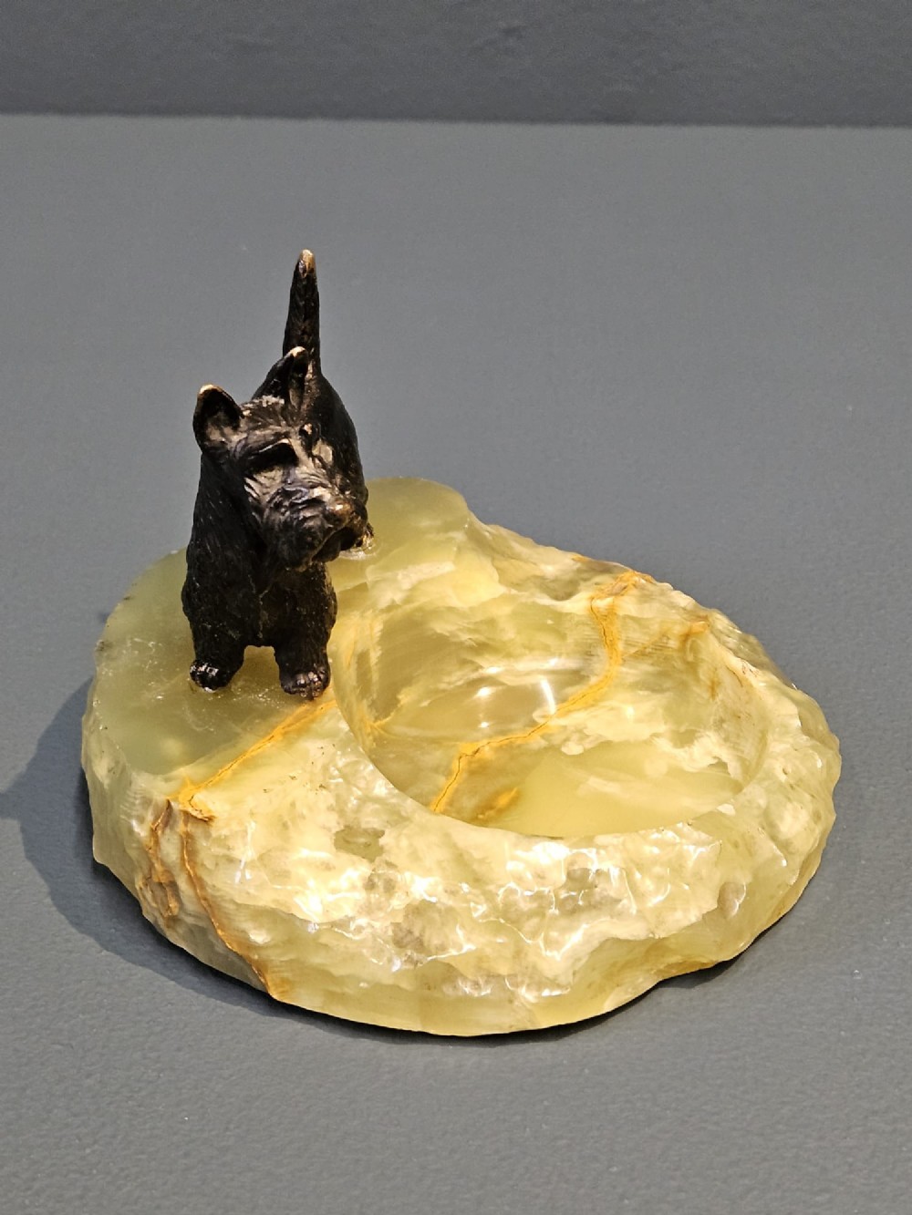 A cold painted bronze Scottish Terrier figure standing on a carved pale green onyx dish with natural veining. View VI