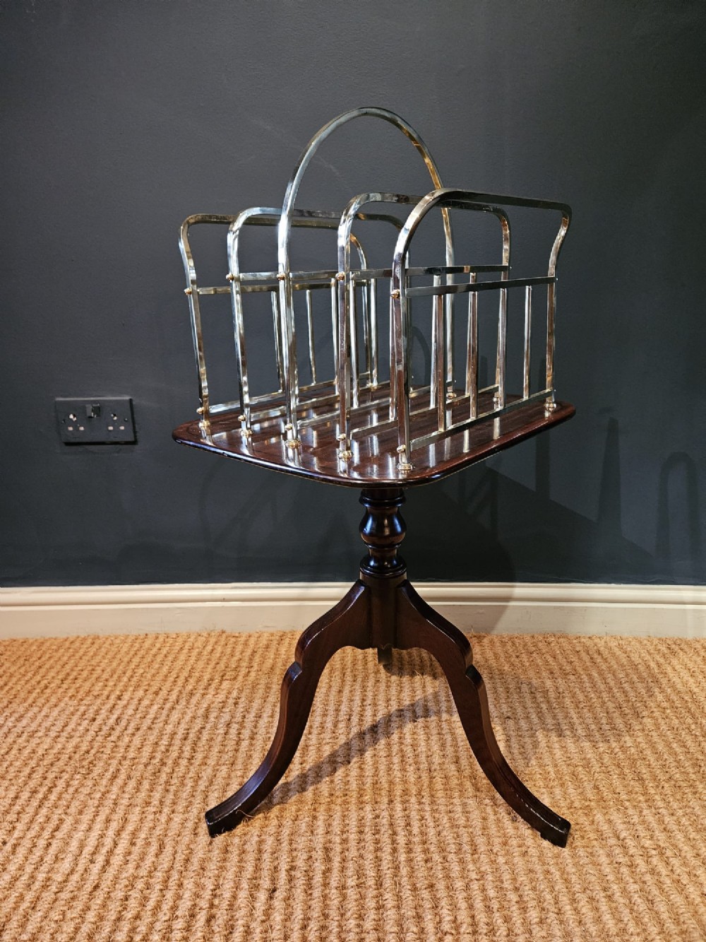 A Victorian brass magazine rack with vertical partitioned dividers mounted atop a polished mahogany tripod table base. View IV