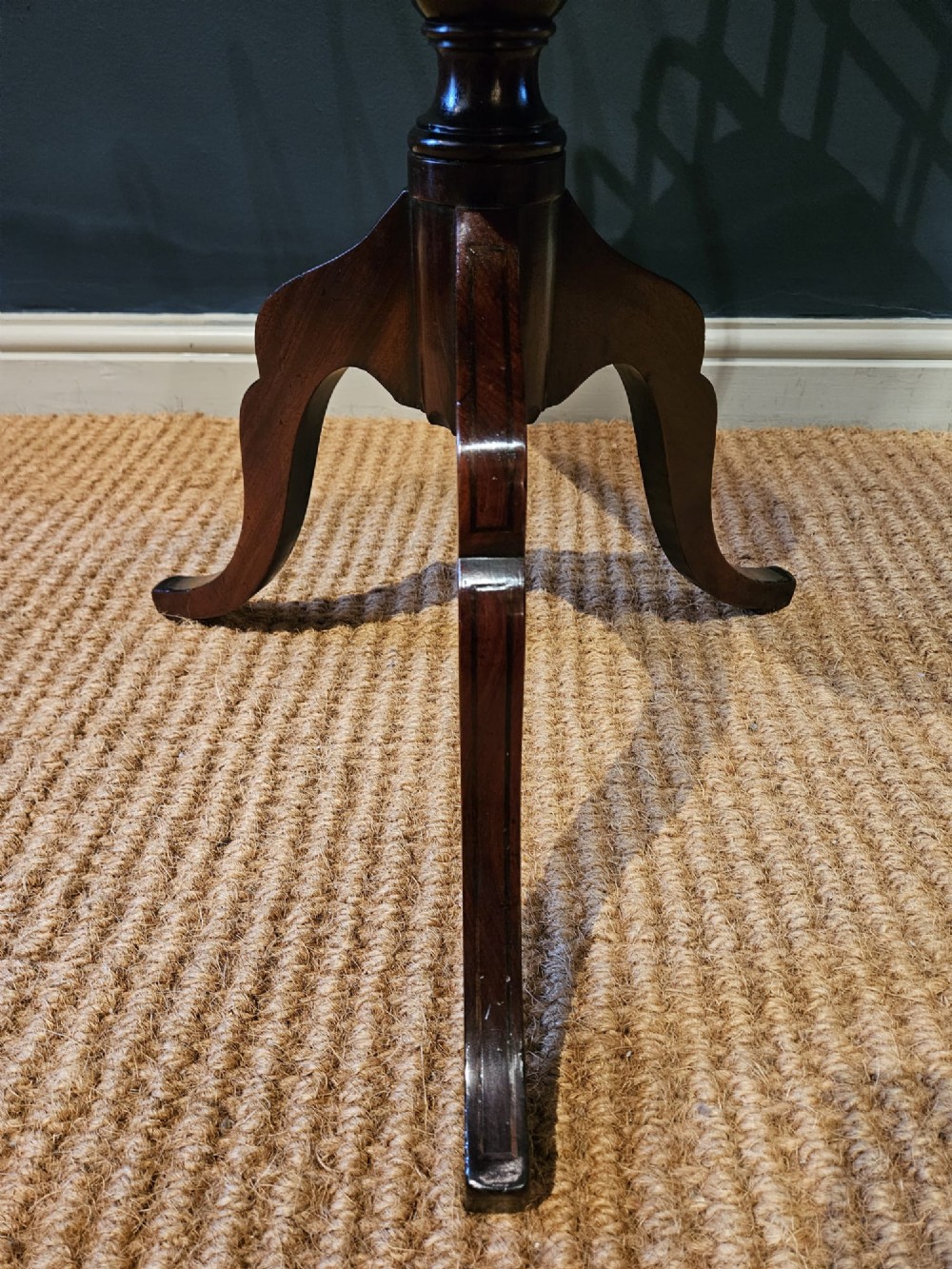 A Victorian brass magazine rack with vertical partitioned dividers mounted atop a polished mahogany tripod table base. View VI