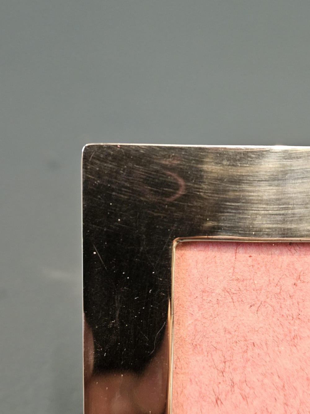 A small rectangular Edwardian polished silver photo frame featuring a plain border and a pink textured insert. View IV