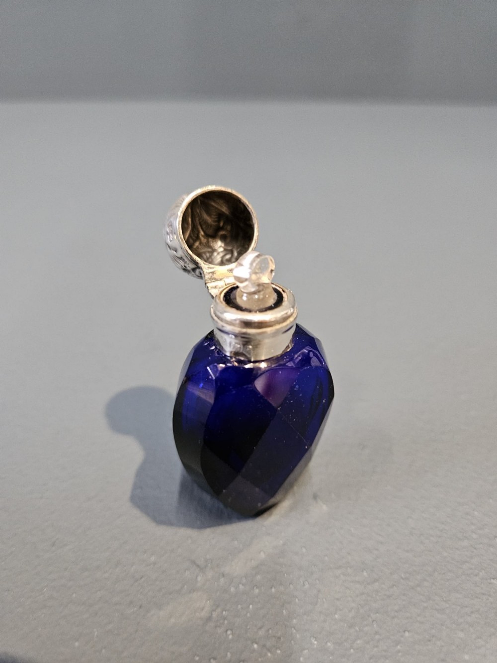 A Victorian faceted cobalt blue glass scent bottle with an engraved sterling silver cap. View II