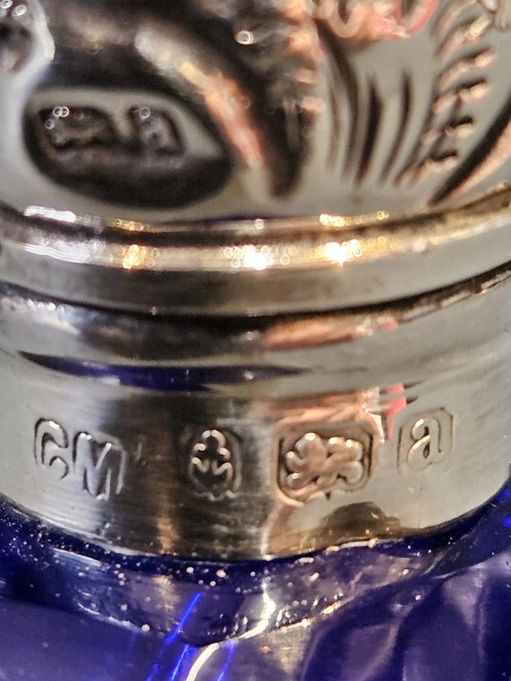 A Victorian faceted cobalt blue glass scent bottle with an engraved sterling silver cap. View VI