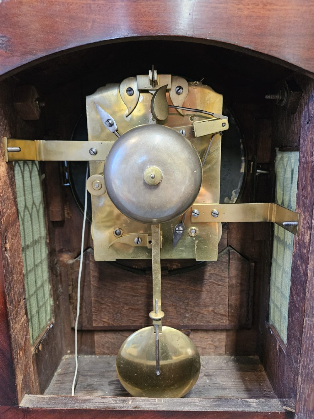 A William IV carved mahogany bracket clock featuring brass inlay decoration, a circular dial with Roman numerals, and a matching wall bracket. View VIII