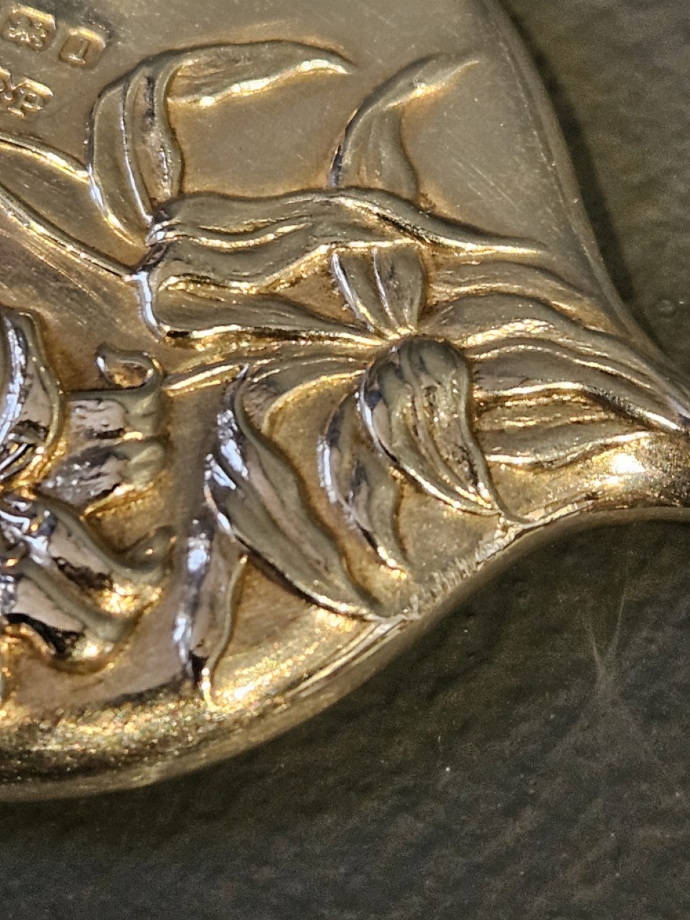 An Edwardian Art Nouveau sterling silver flirting mirror featuring embossed relief floral lily decoration and a suspension ring. View IV