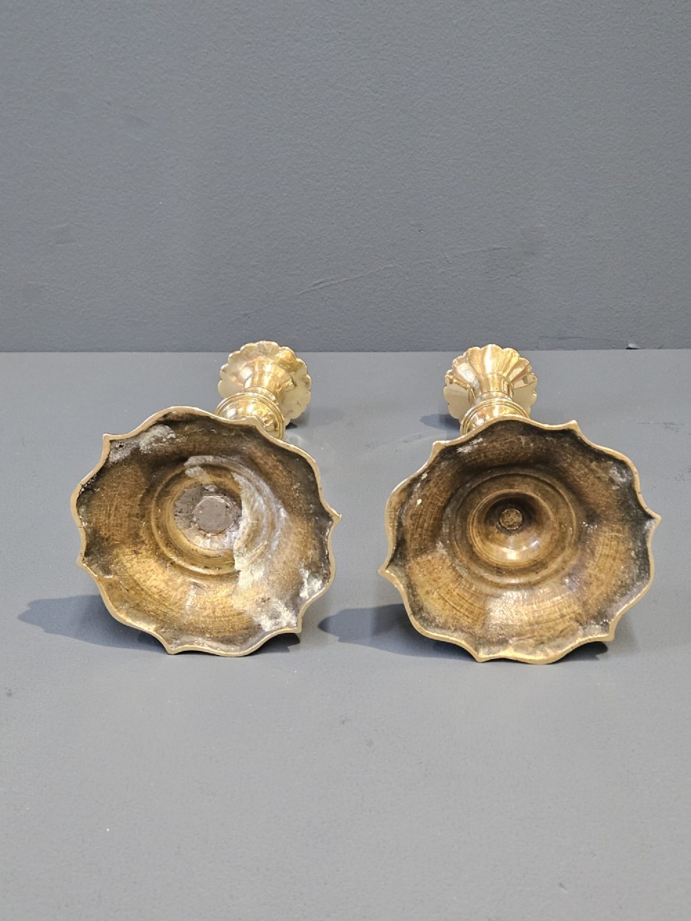 A pair of cast George II brass candlesticks featuring knopped baluster stems and lobed petal-shaped bases. View III