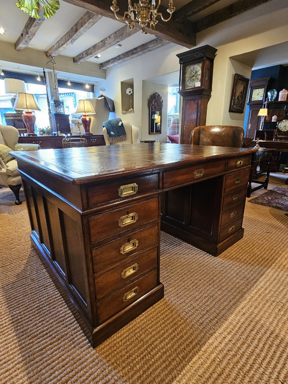 A large Victorian dark oak partners desk featuring dual twin pedestals, inset brass campaign handles, and a leather-topped writing surface.