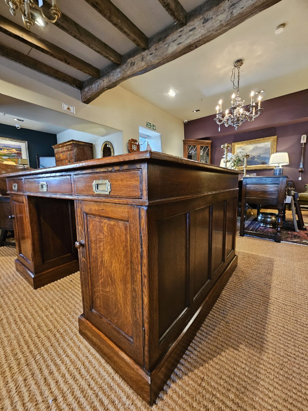 A large Victorian dark oak partners desk featuring dual twin pedestals, inset brass campaign handles, and a leather-topped writing surface. View V