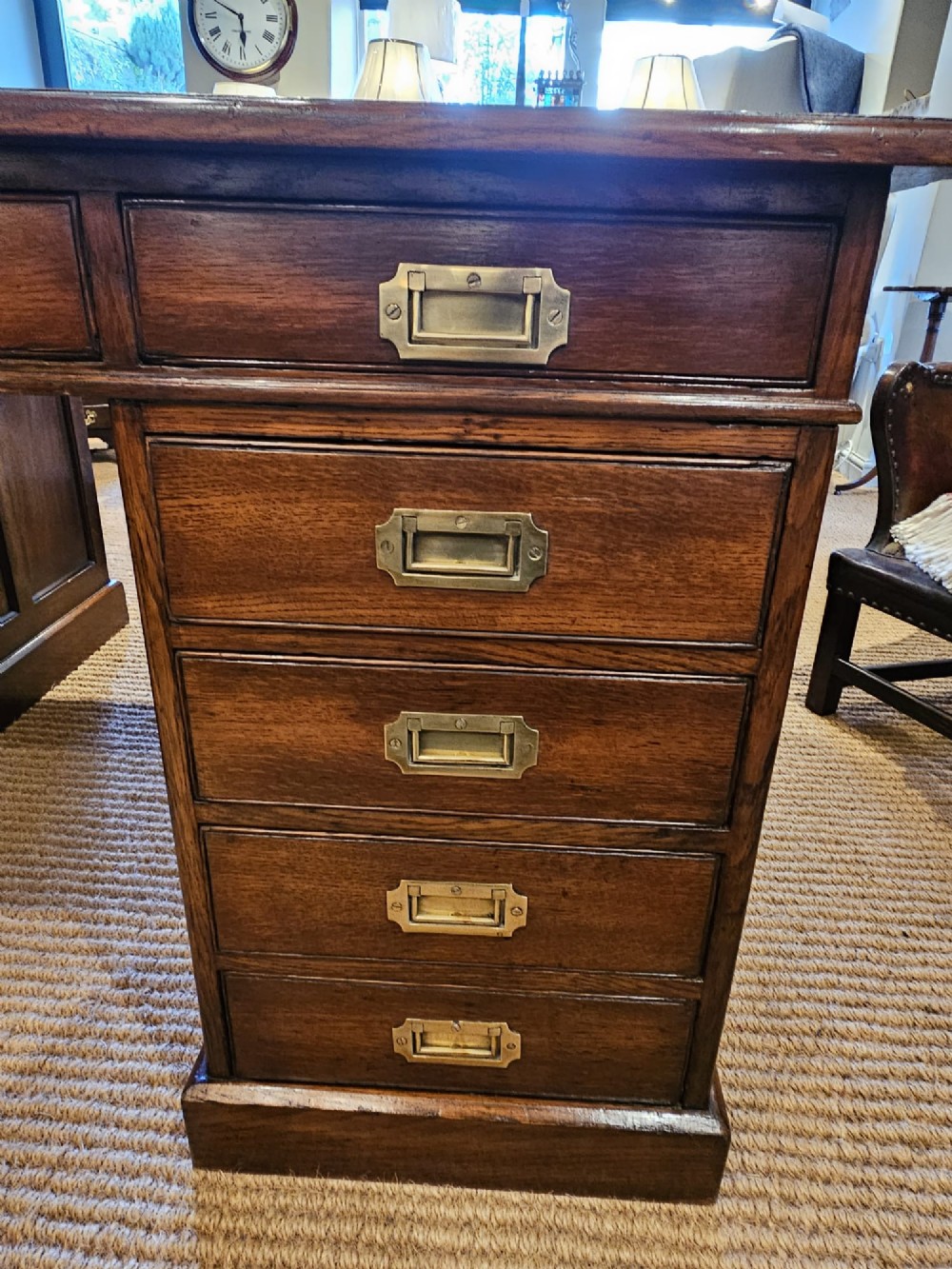A large Victorian dark oak partners desk featuring dual twin pedestals, inset brass campaign handles, and a leather-topped writing surface. View VII