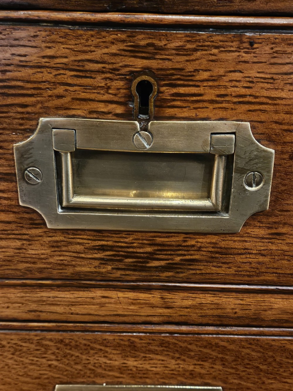 A large Victorian dark oak partners desk featuring dual twin pedestals, inset brass campaign handles, and a leather-topped writing surface. View XII