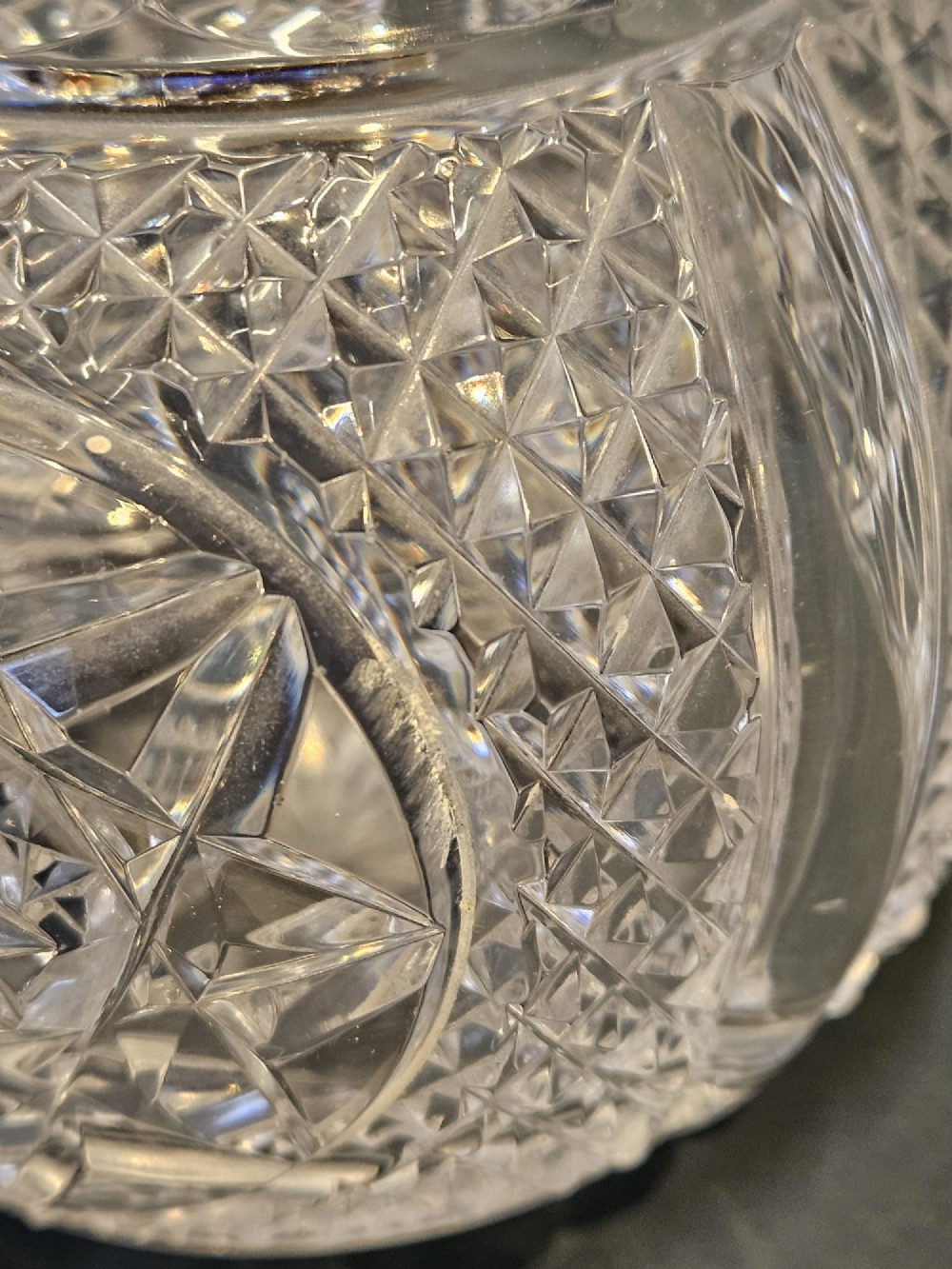 A late Victorian clear cut crystal scent bottle featuring a spherical body with a starburst pattern and an embossed silver cap. View VI