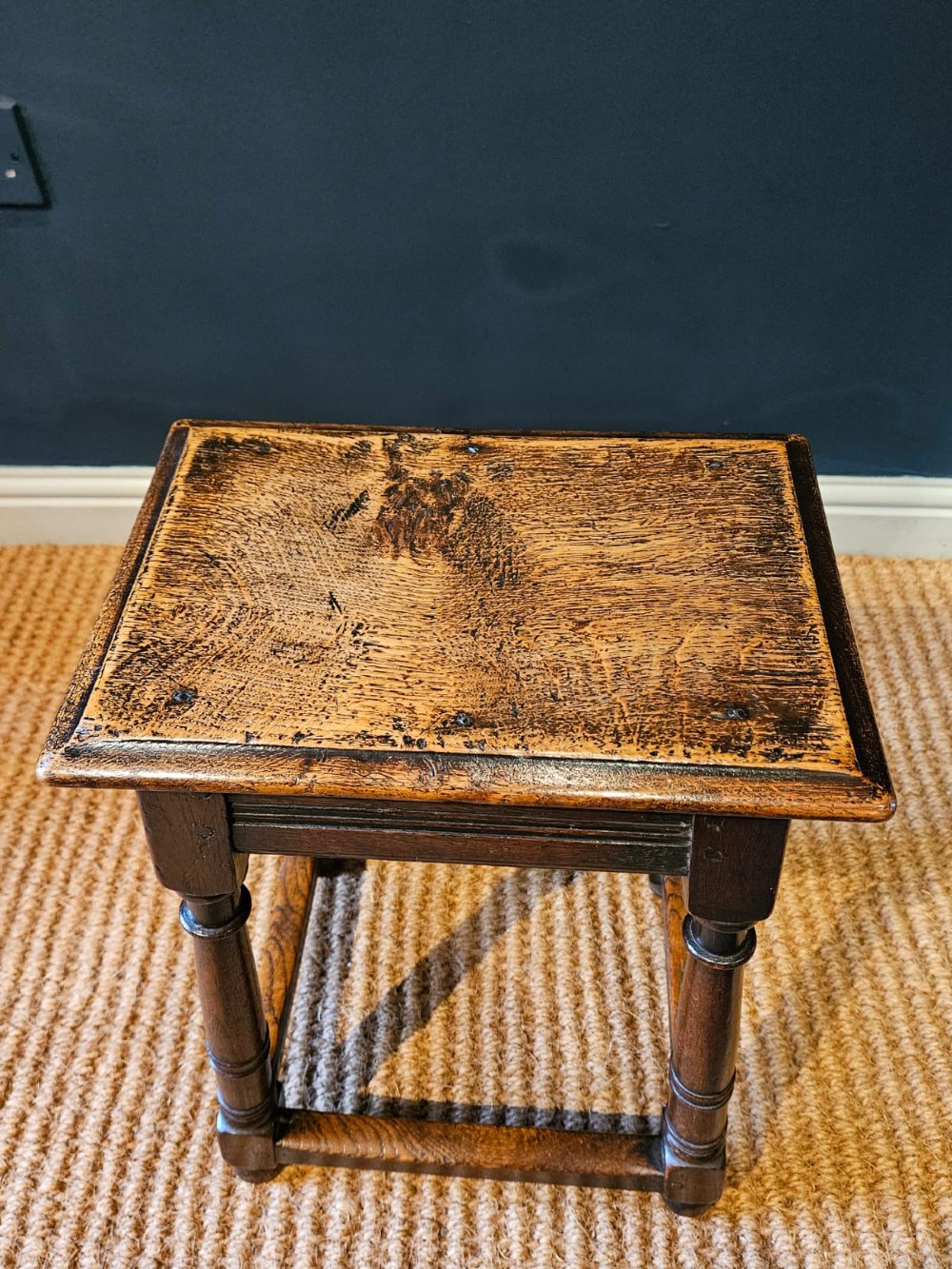 An antique dark oak joint stool featuring a rectangular top, moulded frieze, turned legs, and lower perimeter stretchers. View VIII