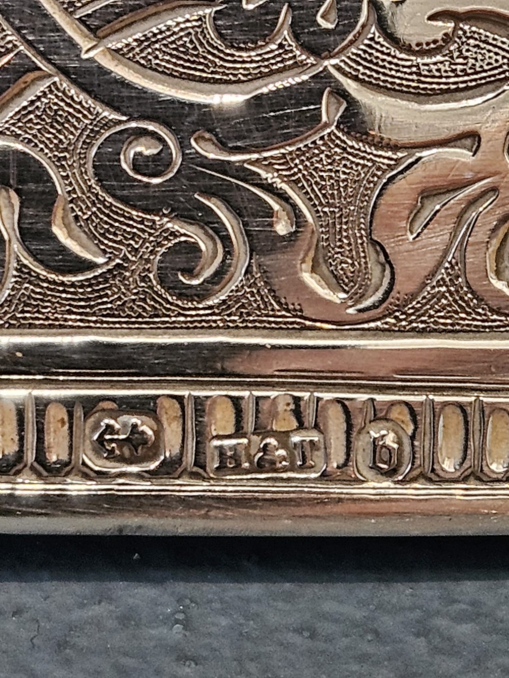 A rectangular Victorian silver card case featuring hand-engraved scrolling foliage, an oval central medallion, and a hinged side edge. View II