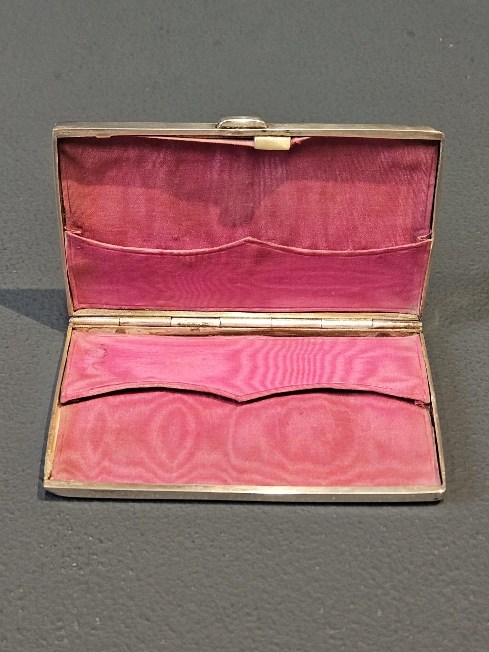 A rectangular Victorian silver card case featuring hand-engraved scrolling foliage, an oval central medallion, and a hinged side edge. View IV