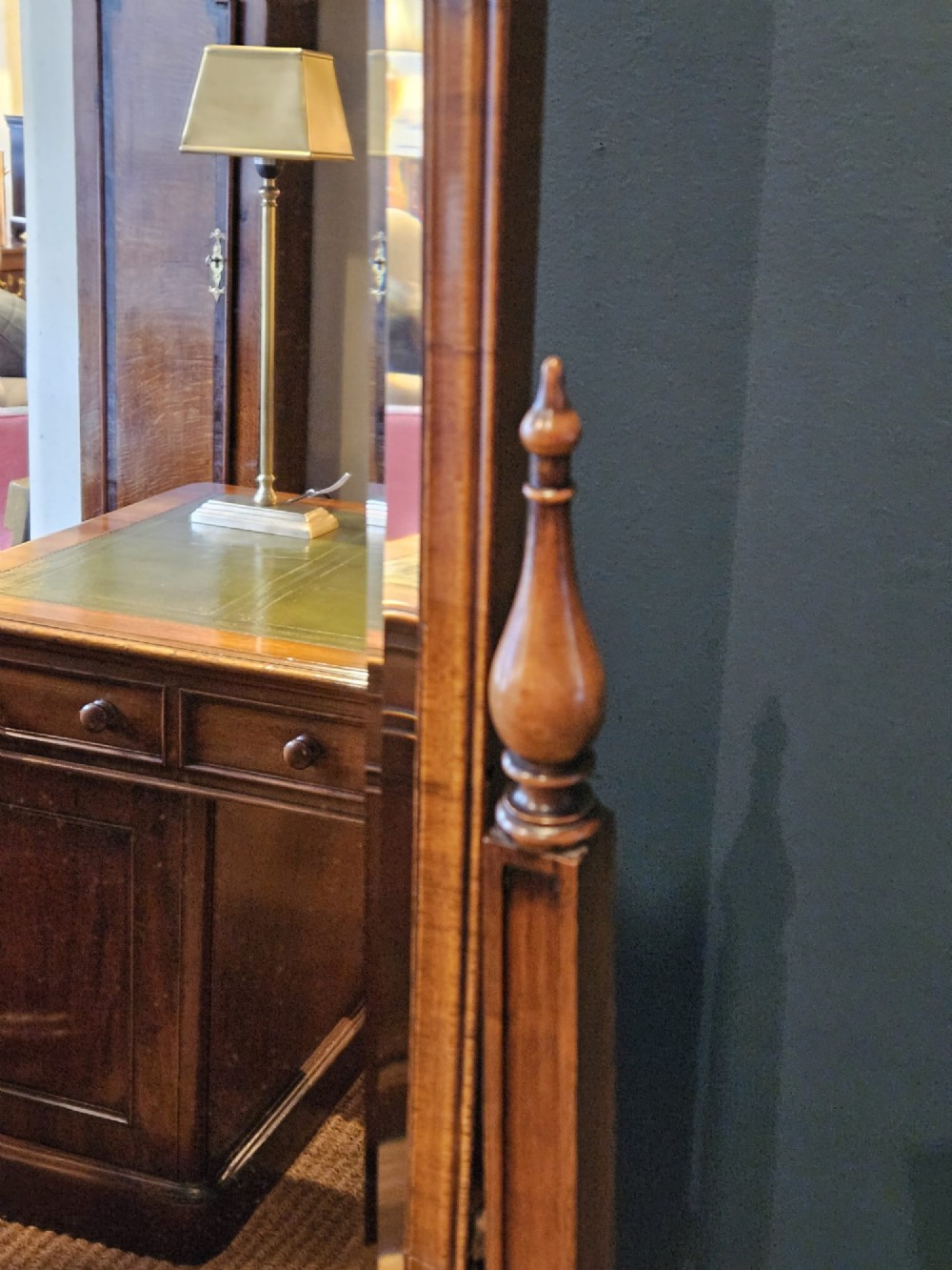 A George III style mahogany cheval mirror featuring an arched top with a carved shell cresting, turned side finials, and splayed legs on brass castors. View VIII