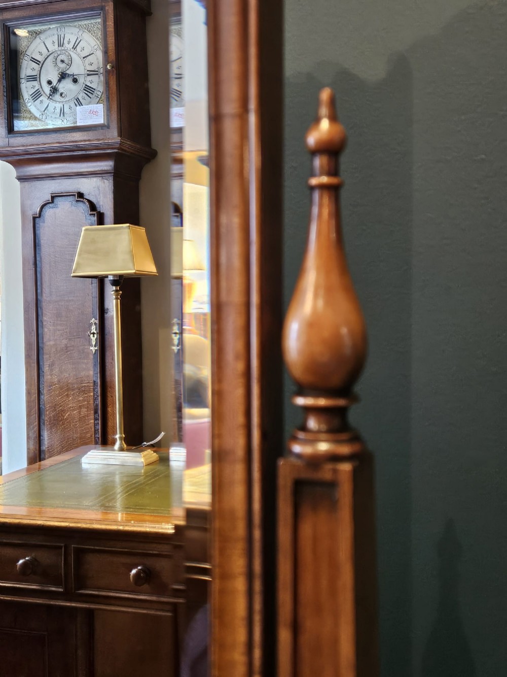 A George III style mahogany cheval mirror featuring an arched top with a carved shell cresting, turned side finials, and splayed legs on brass castors. View IX