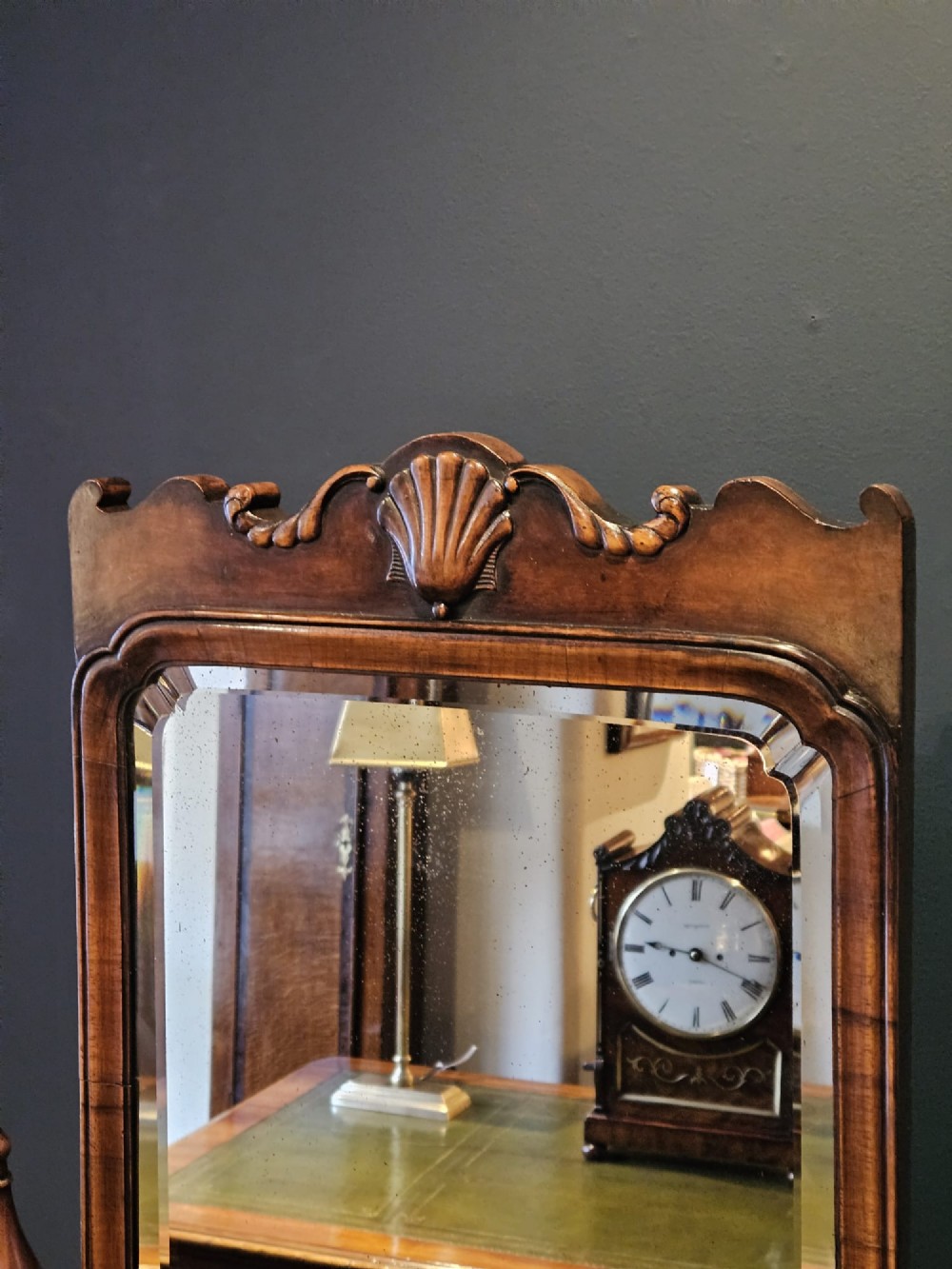 A George III style mahogany cheval mirror featuring an arched top with a carved shell cresting, turned side finials, and splayed legs on brass castors. View X