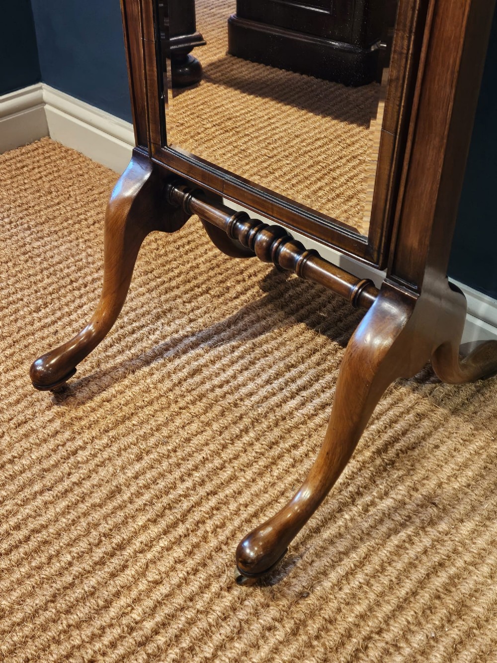 A George III style mahogany cheval mirror featuring an arched top with a carved shell cresting, turned side finials, and splayed legs on brass castors. View XI
