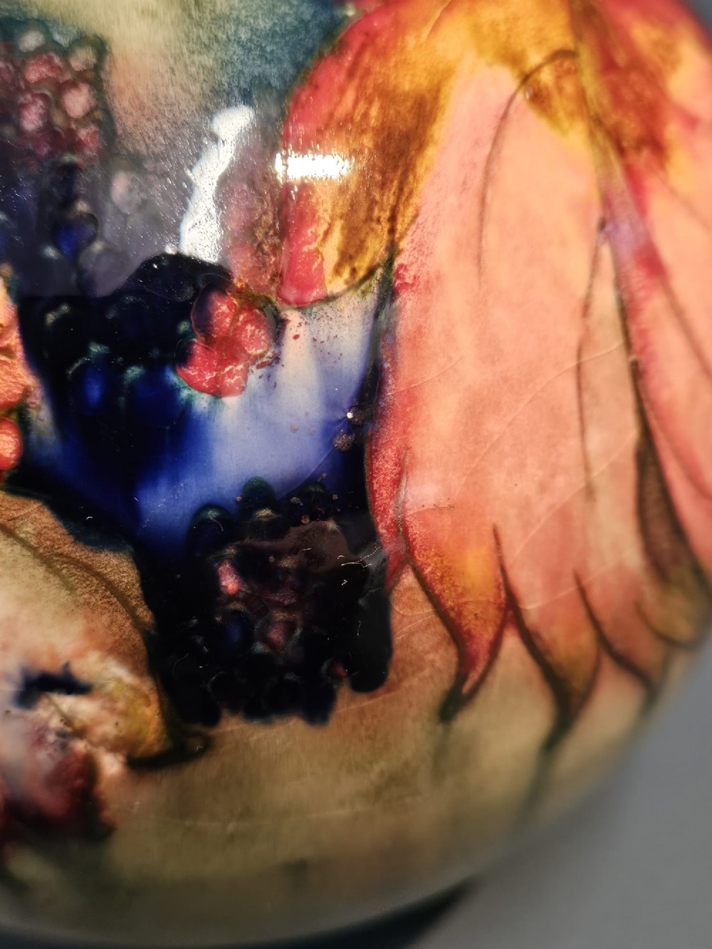 A spherical Moorcroft pottery vase decorated with a tubelined leaf and blackberry pattern under a glossy flambe glaze. View III