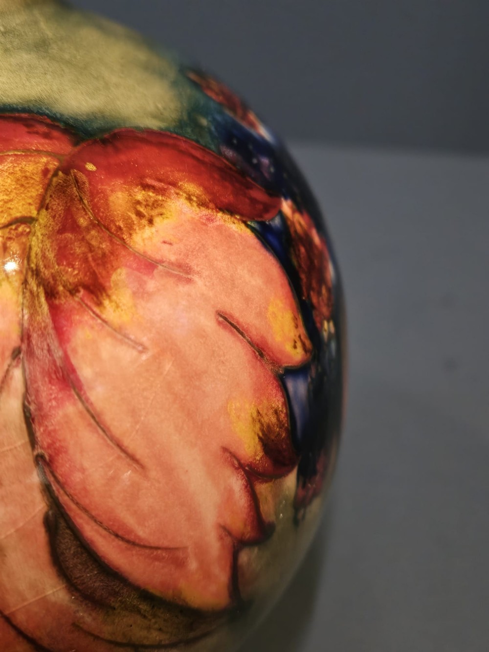 A spherical Moorcroft pottery vase decorated with a tubelined leaf and blackberry pattern under a glossy flambe glaze. View IV