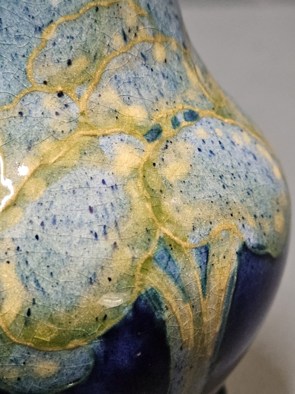 A small baluster-shaped ceramic vase featuring tubelined tree motifs in tones of green and turquoise over a deep cobalt blue glaze. View IV