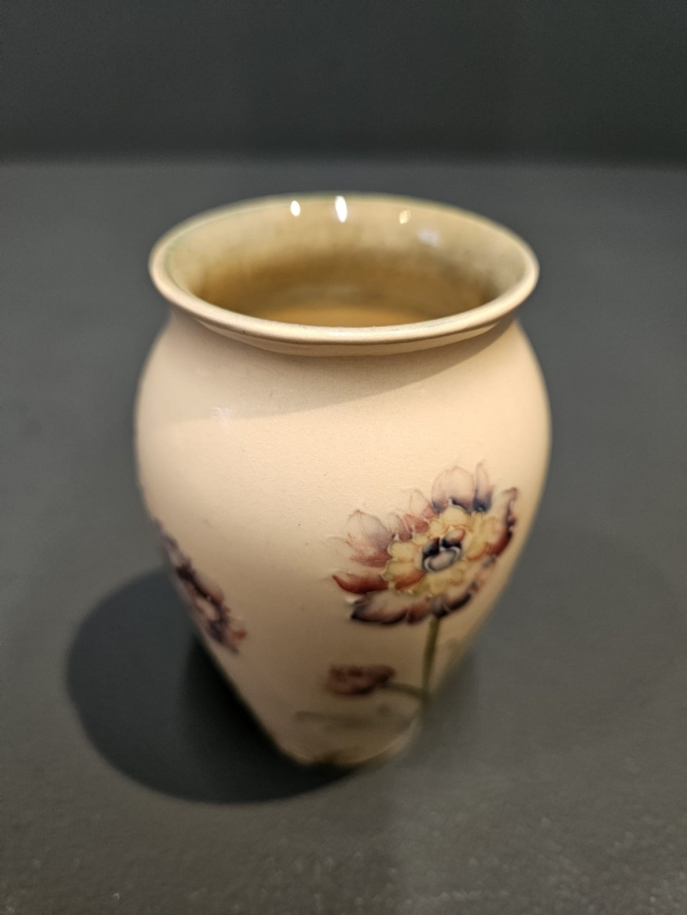 A cream earthenware vase decorated with tubelined pink cornflowers and green foliage in an Art Nouveau design. View IV