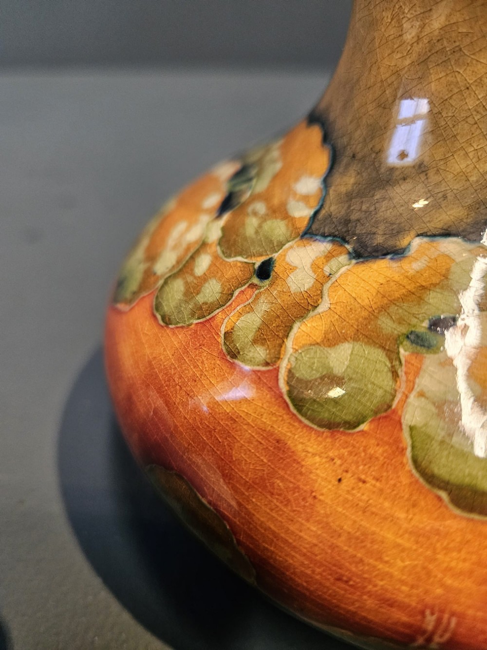 A small squat earthenware Moorcroft Eventide vase featuring tubelined trees against an orange and ochre twilight ground. View IV
