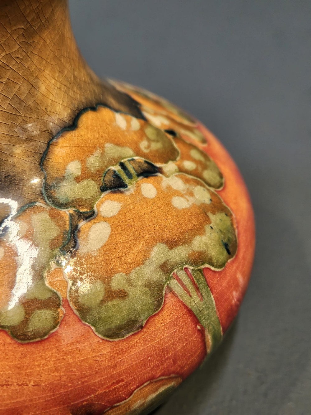 A small squat earthenware Moorcroft Eventide vase featuring tubelined trees against an orange and ochre twilight ground. View VII