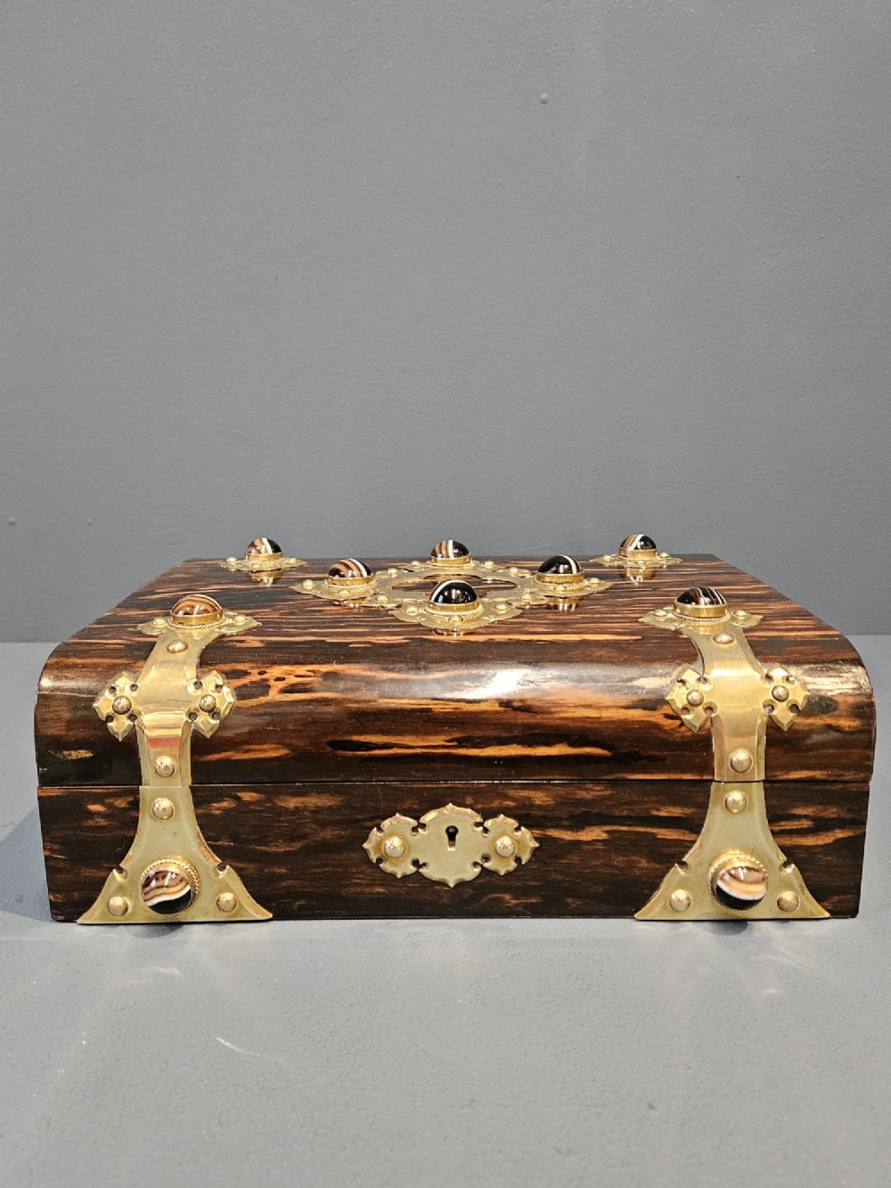 A dark coromandel wood box featuring decorative brass strapwork inset with rounded agate cabochons. View III