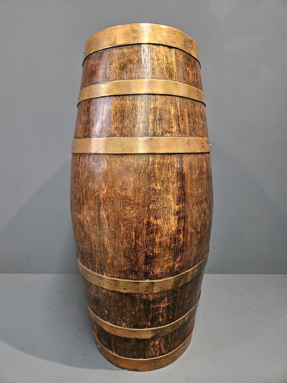 A Victorian dark oak coopered barrel stick stand fitted with brass hoops and displaying a royal coat of arms crest on the front. View VI