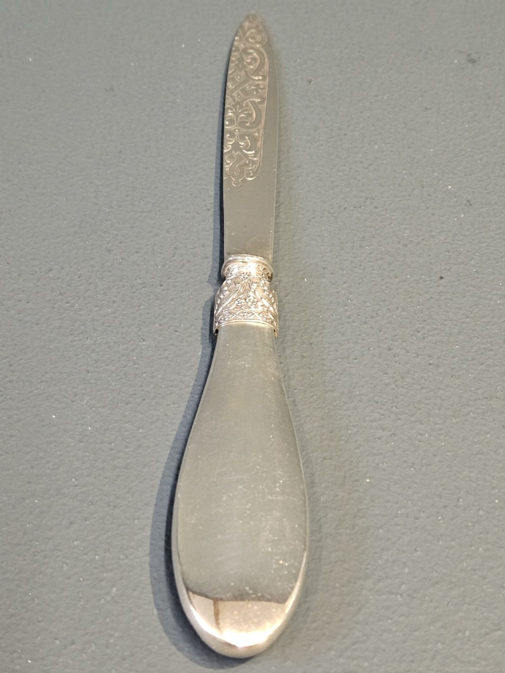 A Victorian silver and tortoiseshell paper knife featuring an engraved silver blade with hallmarks and an inlaid tortoiseshell handle. View V