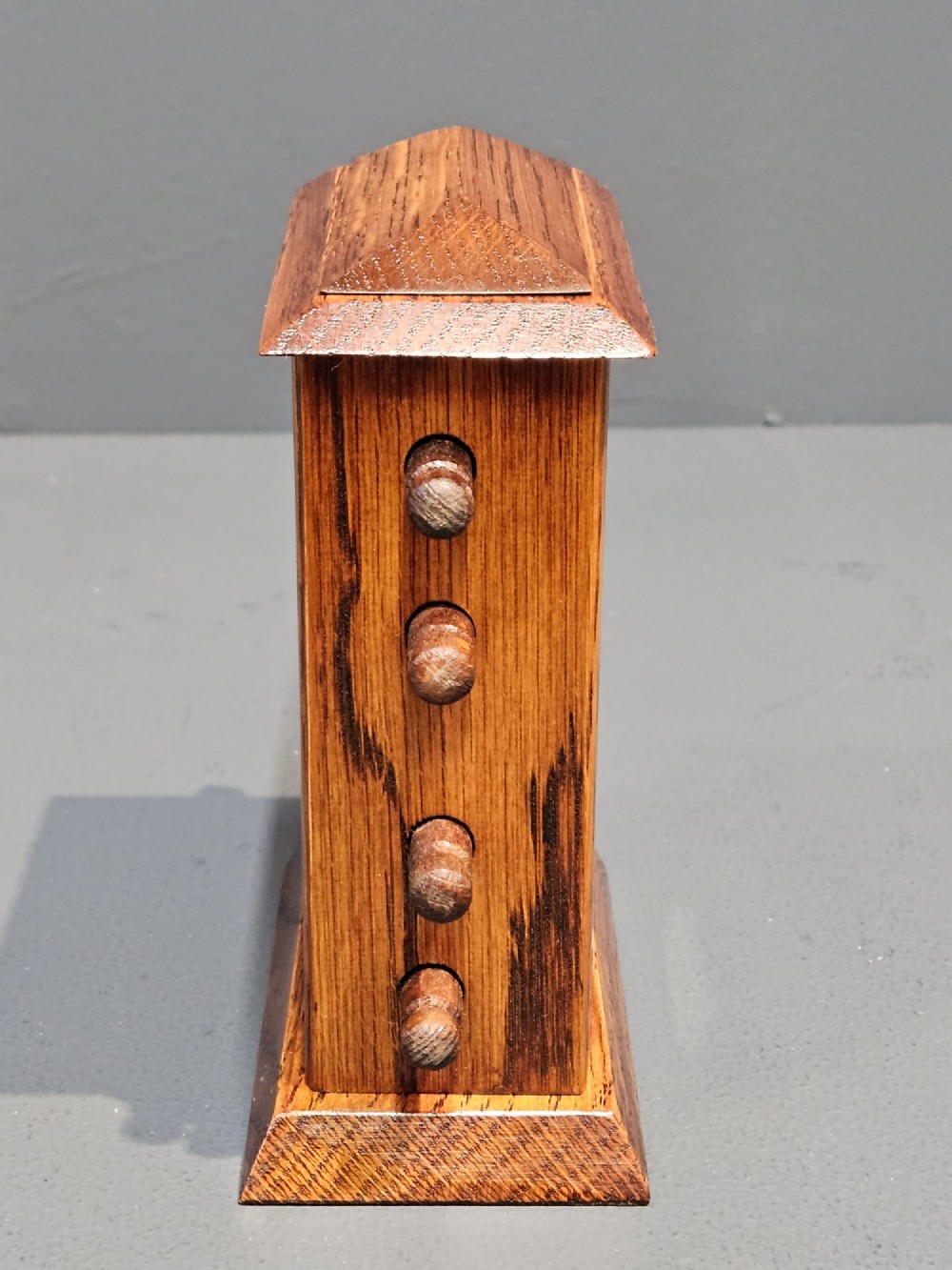 An Edwardian oak perpetual desk calendar featuring four side adjustment knobs, a moulded top, and cut-out apertures displaying the day, date, and month. View III