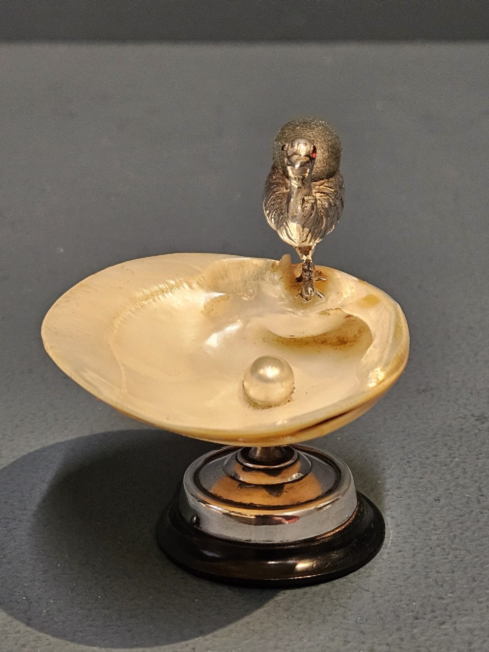 An Edwardian sterling silver emu figurine with an embedded fabric pin cushion, mounted on a polished mother-of-pearl shell dish. View VII