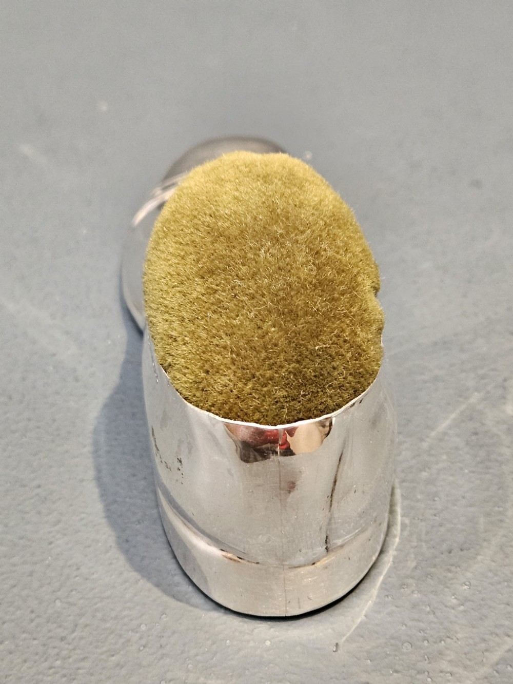 An Edwardian hallmarked sterling silver pin cushion shaped like a gentlemans shoe with an olive green velvet cushion top. View III