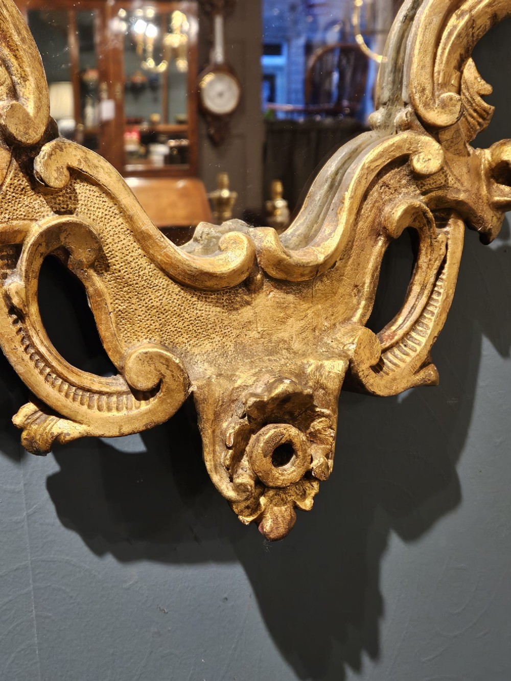 A mid-Victorian lozenge-shaped wall mirror featuring an ornate gold leaf giltwood frame decorated with scrolls and acanthus leaf cresting. View III