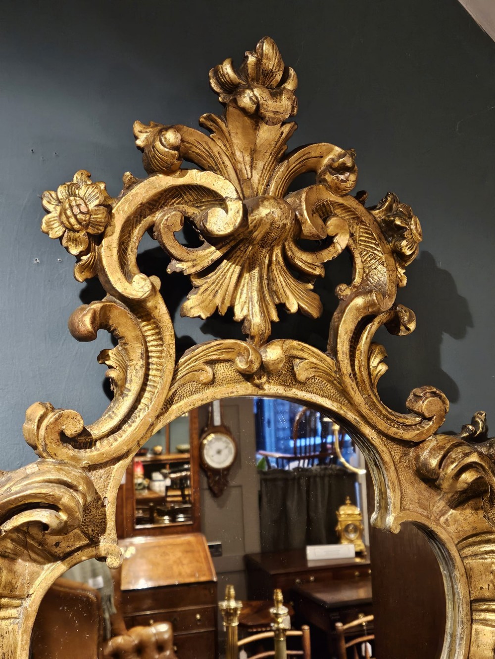 A mid-Victorian lozenge-shaped wall mirror featuring an ornate gold leaf giltwood frame decorated with scrolls and acanthus leaf cresting. View IV