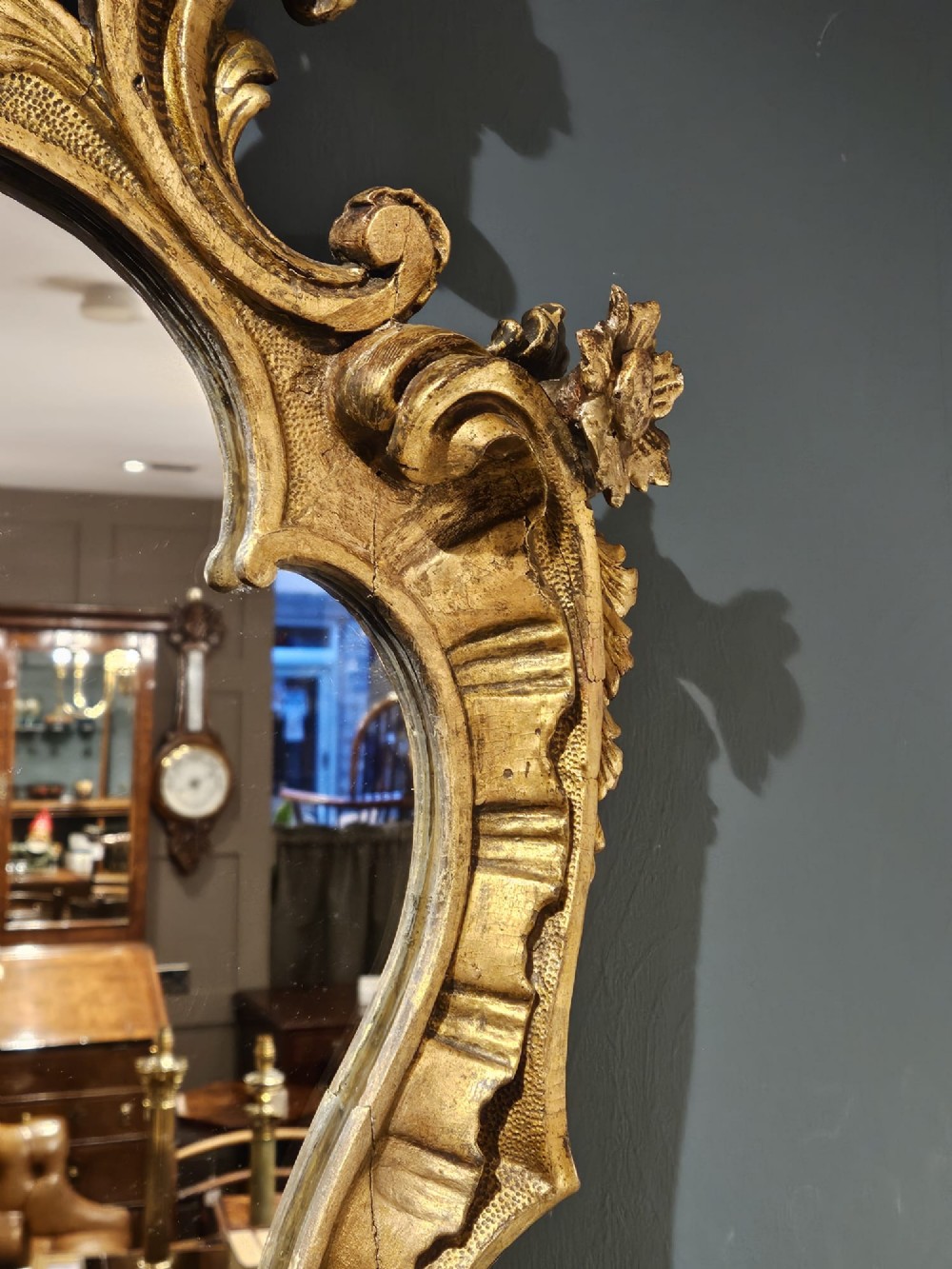 A mid-Victorian lozenge-shaped wall mirror featuring an ornate gold leaf giltwood frame decorated with scrolls and acanthus leaf cresting. View VIII