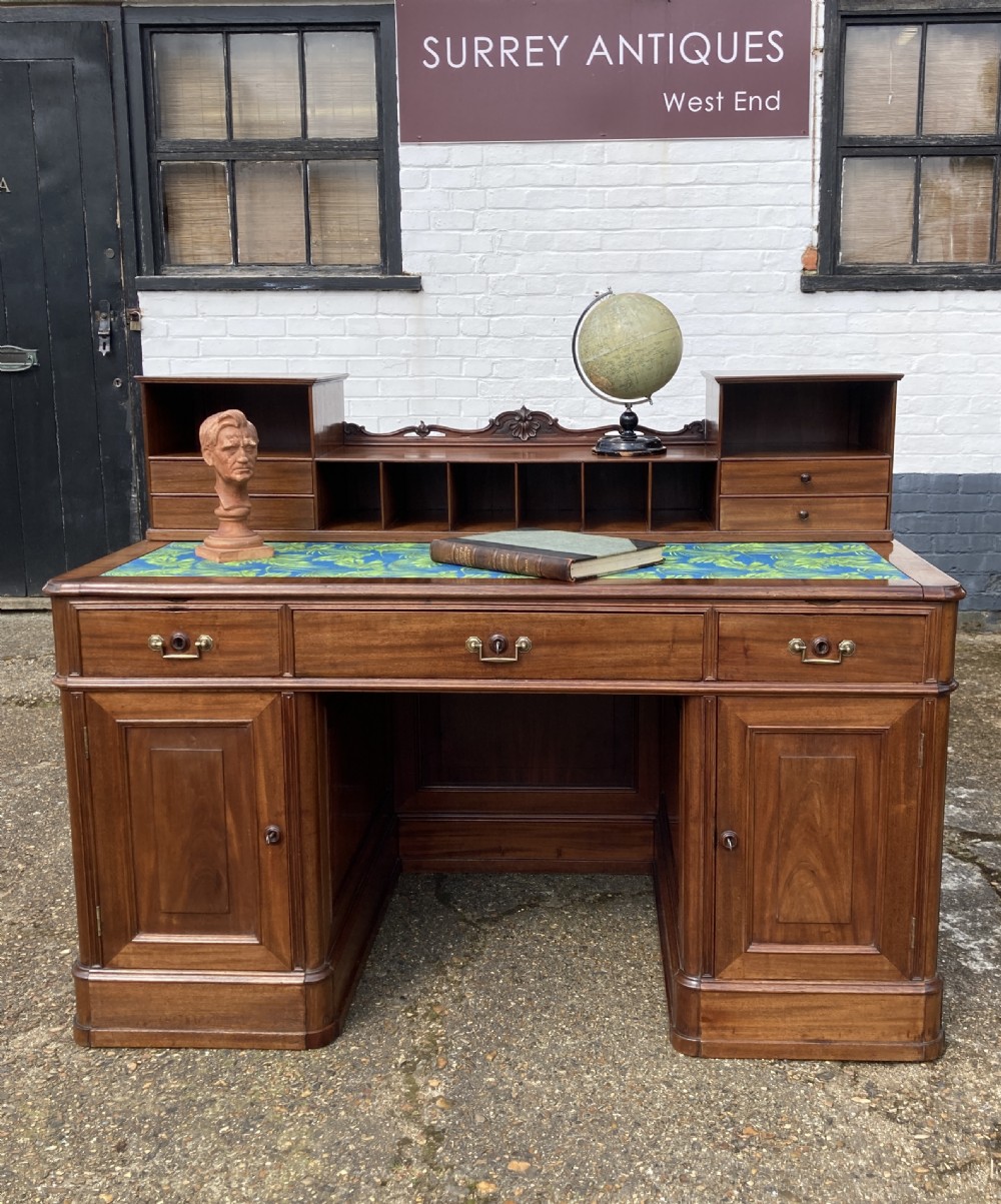 A mid-19th-century Italian mahogany pedestal desk featuring a raised superstructure with pigeonholes, frieze drawers, and twin pedestal cupboards.