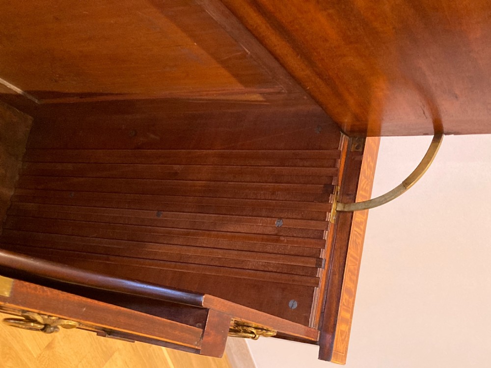 A late 18th-century George III breakfront wooden side cabinet featuring central and flanking drawers above doors decorated with oval satinwood marquetry panels and brass ring handles. View XIV