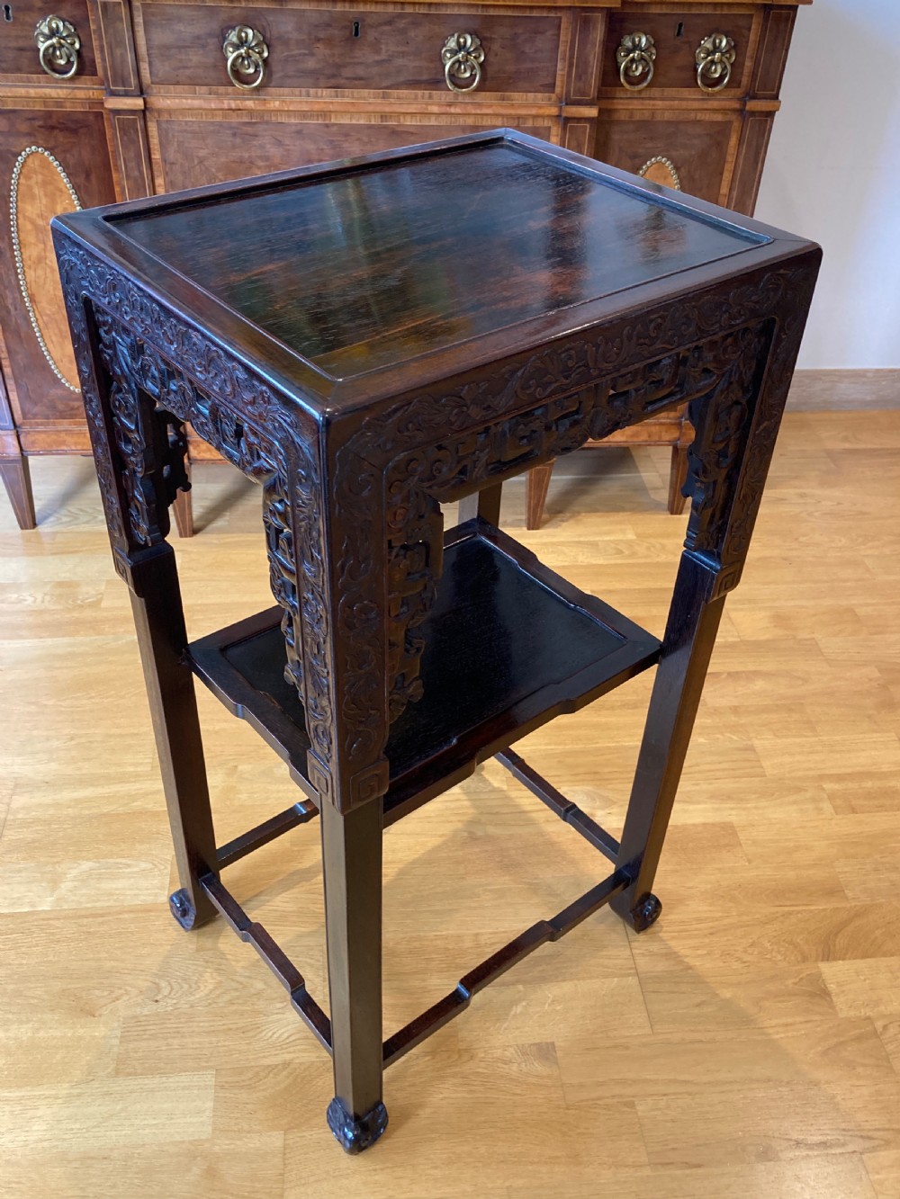 A two-tier dark brown carved hardwood square pedestal stand featuring openwork aprons and straight legs. View VI