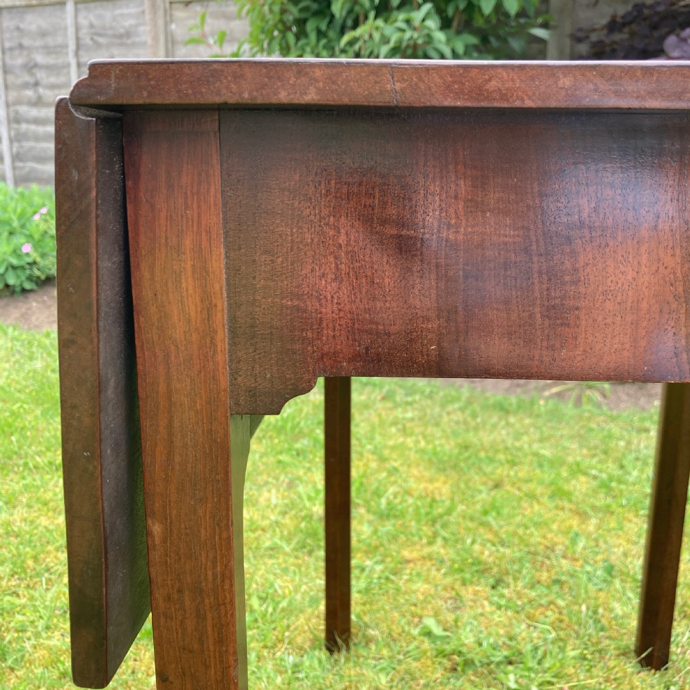 A Georgian mahogany Pembroke table featuring two drop-leaf sides and four square tapered legs. View X
