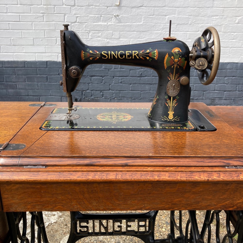 An oak-cased Singer sewing machine side table with side drawers mounted on a black cast iron treadle base. View III