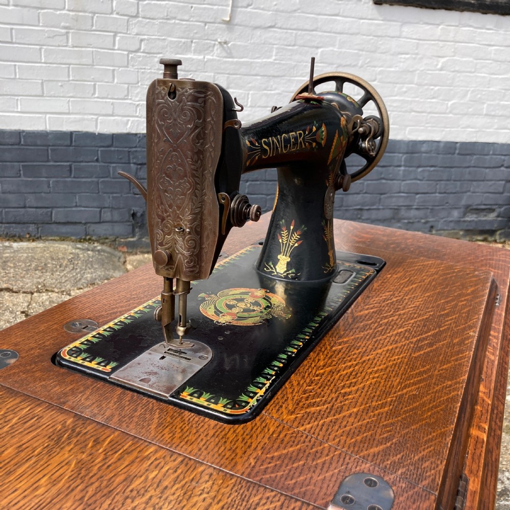An oak-cased Singer sewing machine side table with side drawers mounted on a black cast iron treadle base. View IV